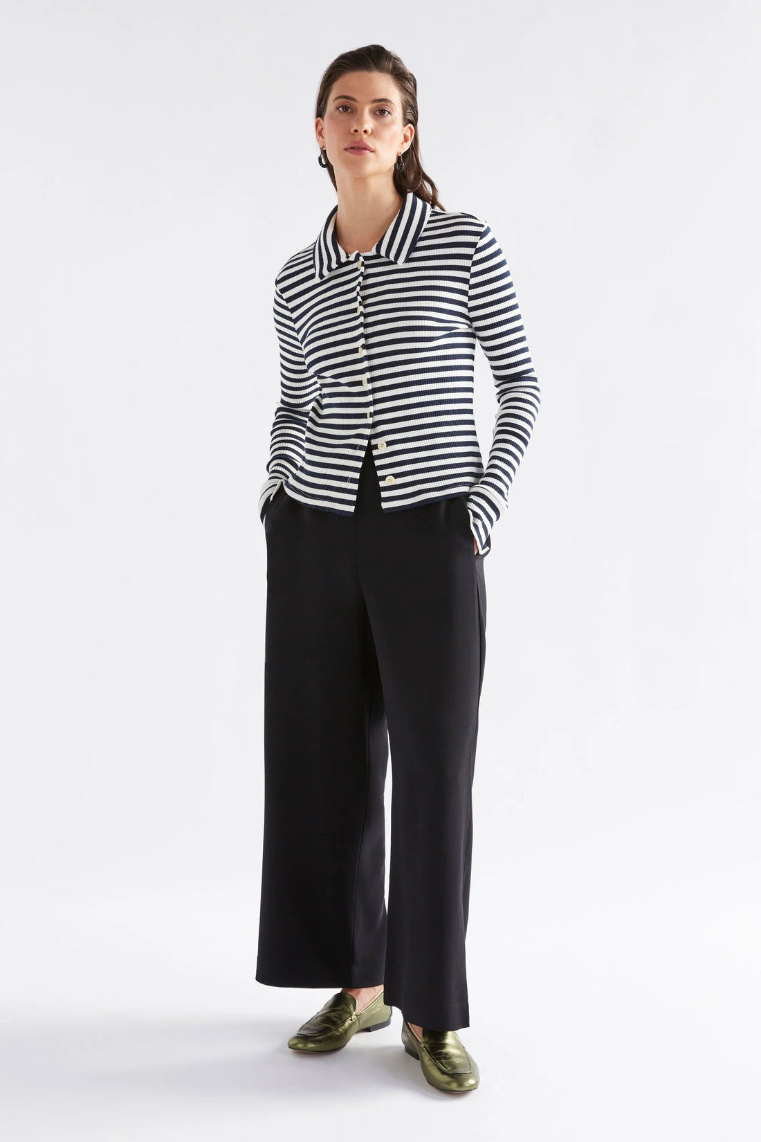 woman wearing white and black stripe top and black pants