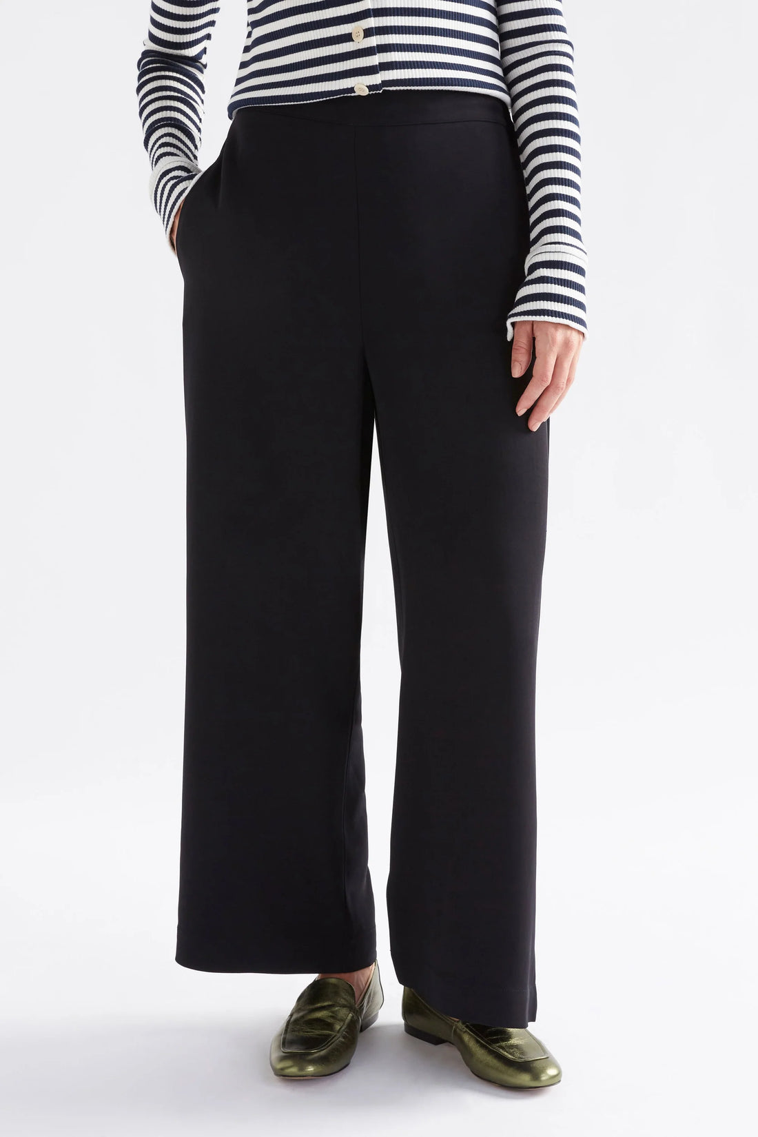 woman wearing white and black stripe top and black pants
