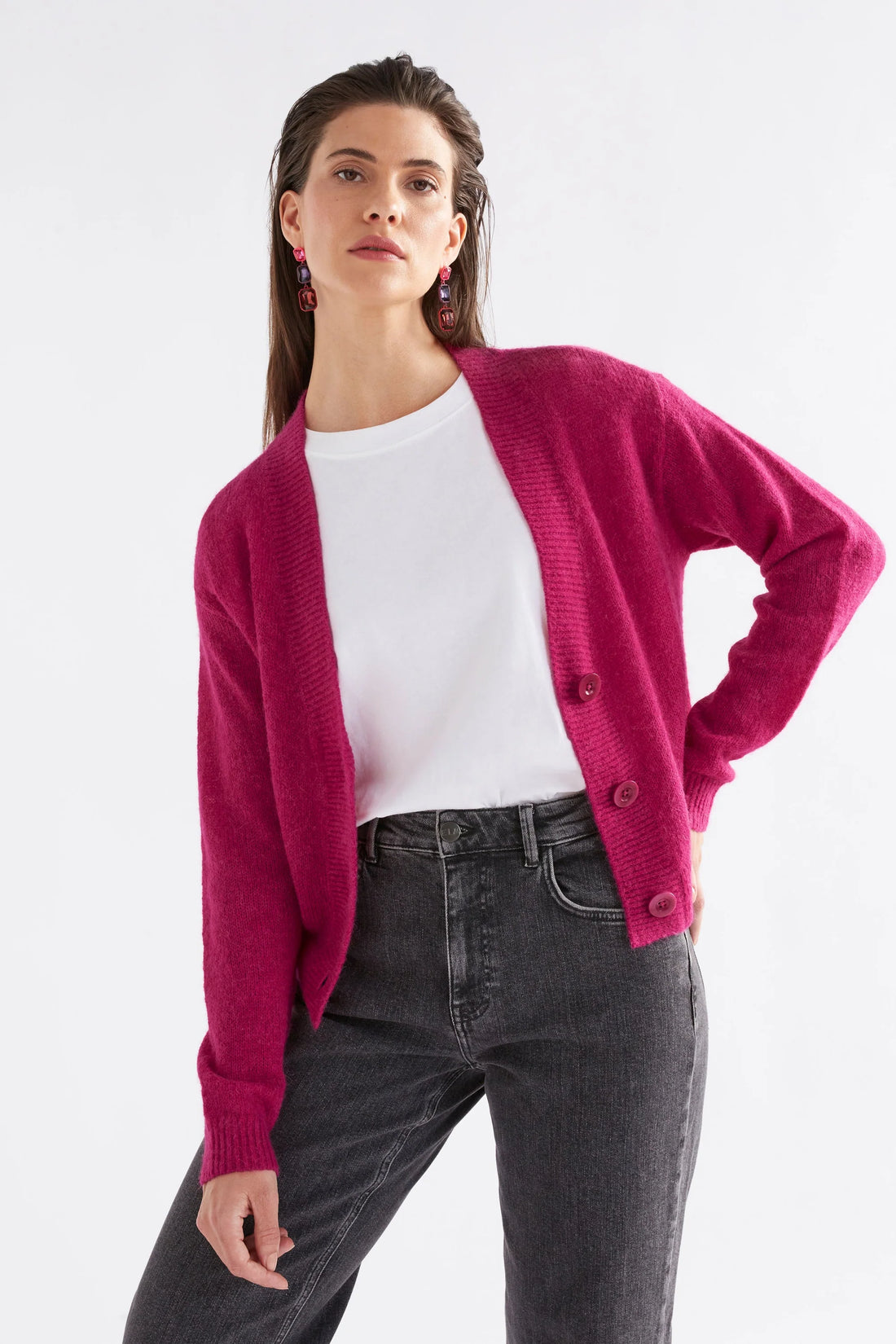 Woman wearing white top with Daru Cardigan in Bright pink and black denim pants