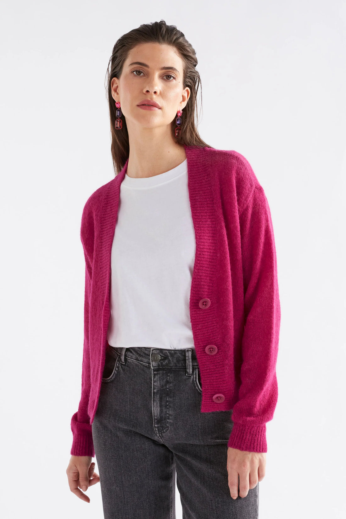 Woman wearing white top with Daru Cardigan in Bright pink and black denim pants