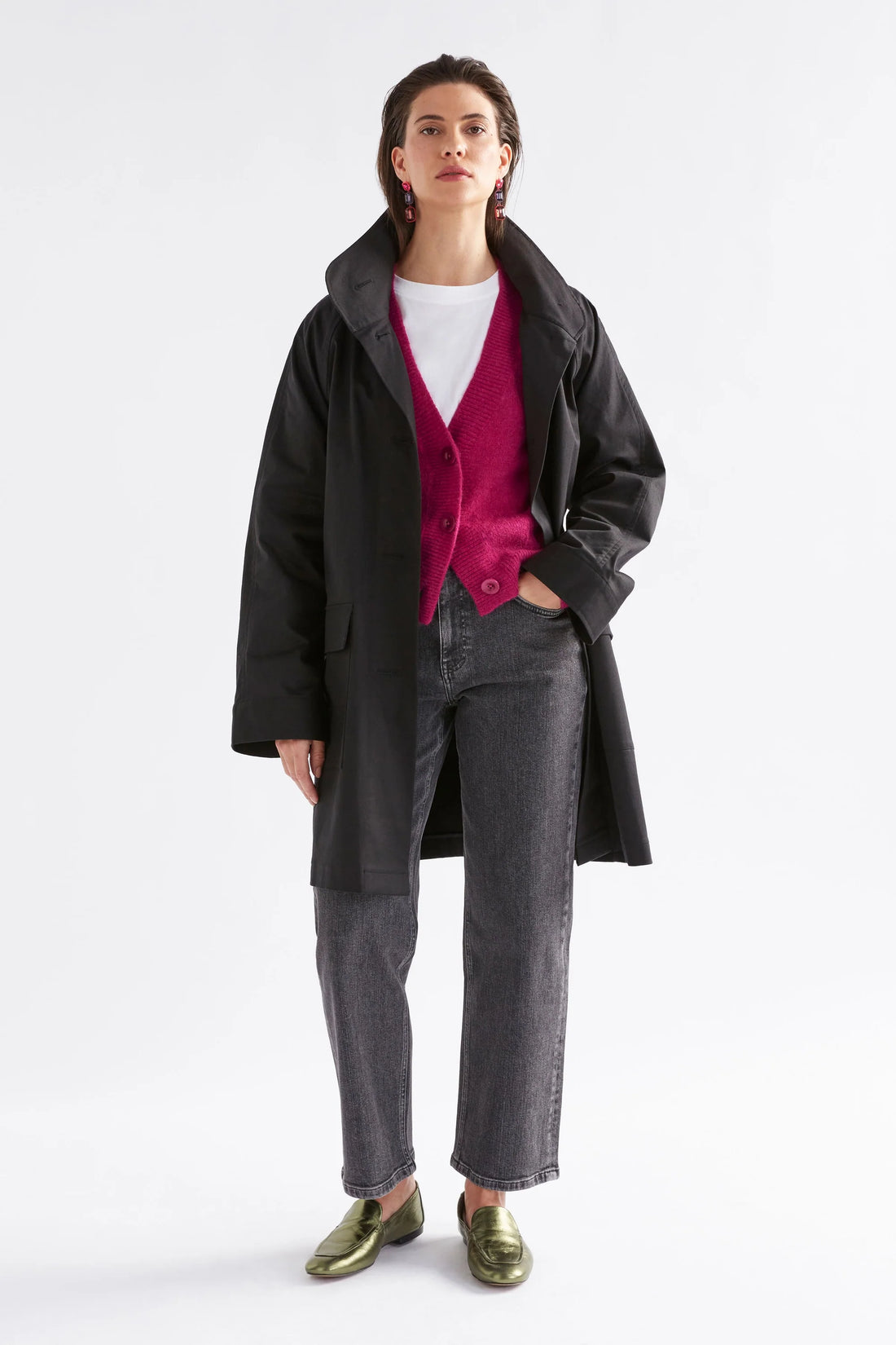 Woman facing the back wearing white top with Daru Cardigan in Bright pink and black denim pants with black coat