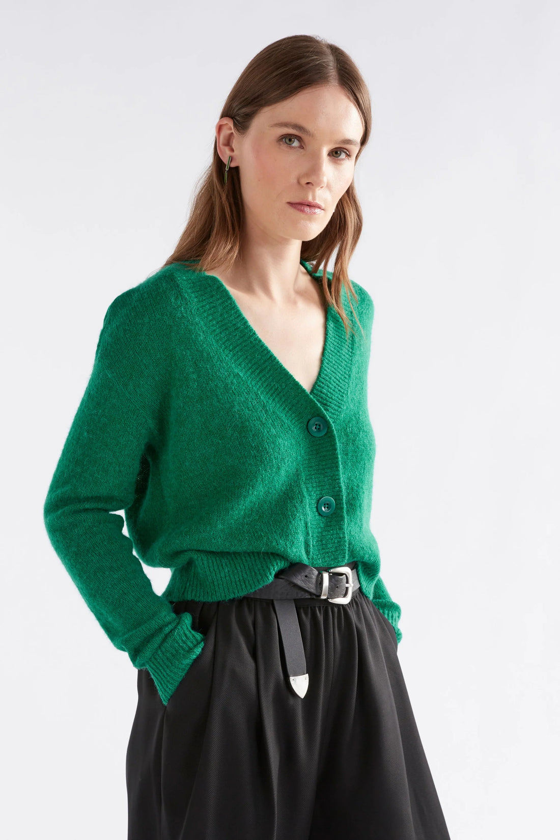 Woman wearing Daaru Cardigan in Milan Green and black pants