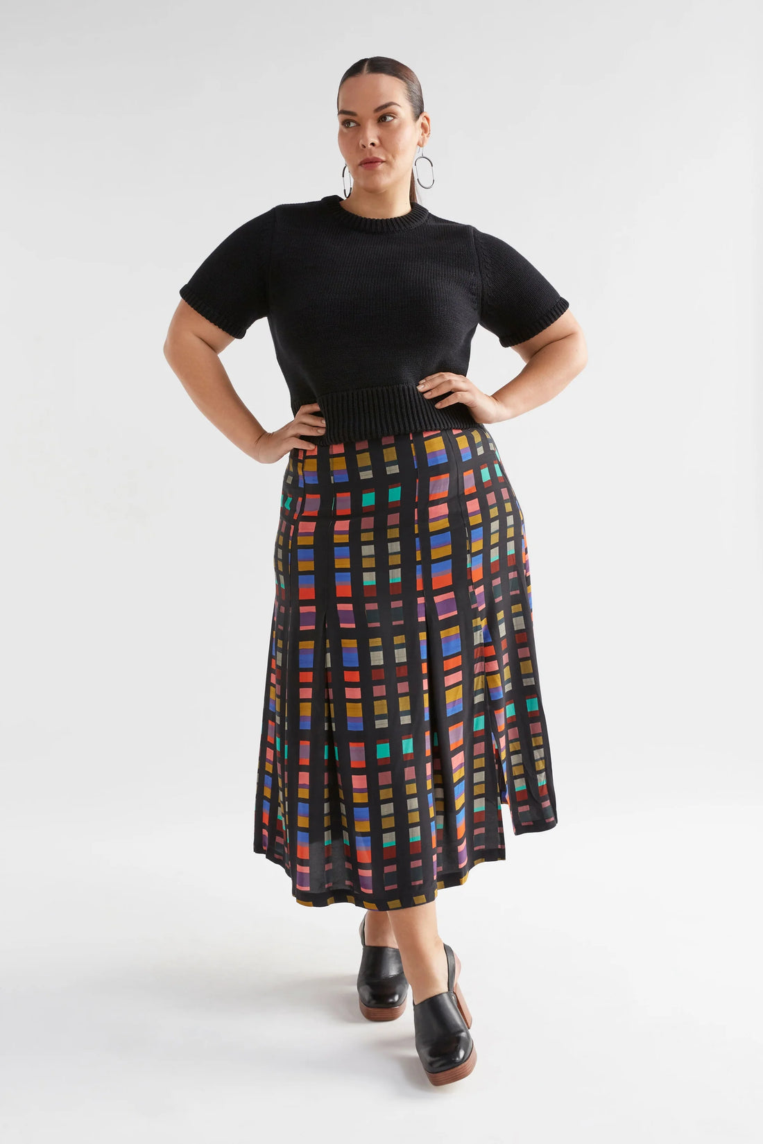 Plus size Woman wearing black luft knit top and multi-coloured skirt