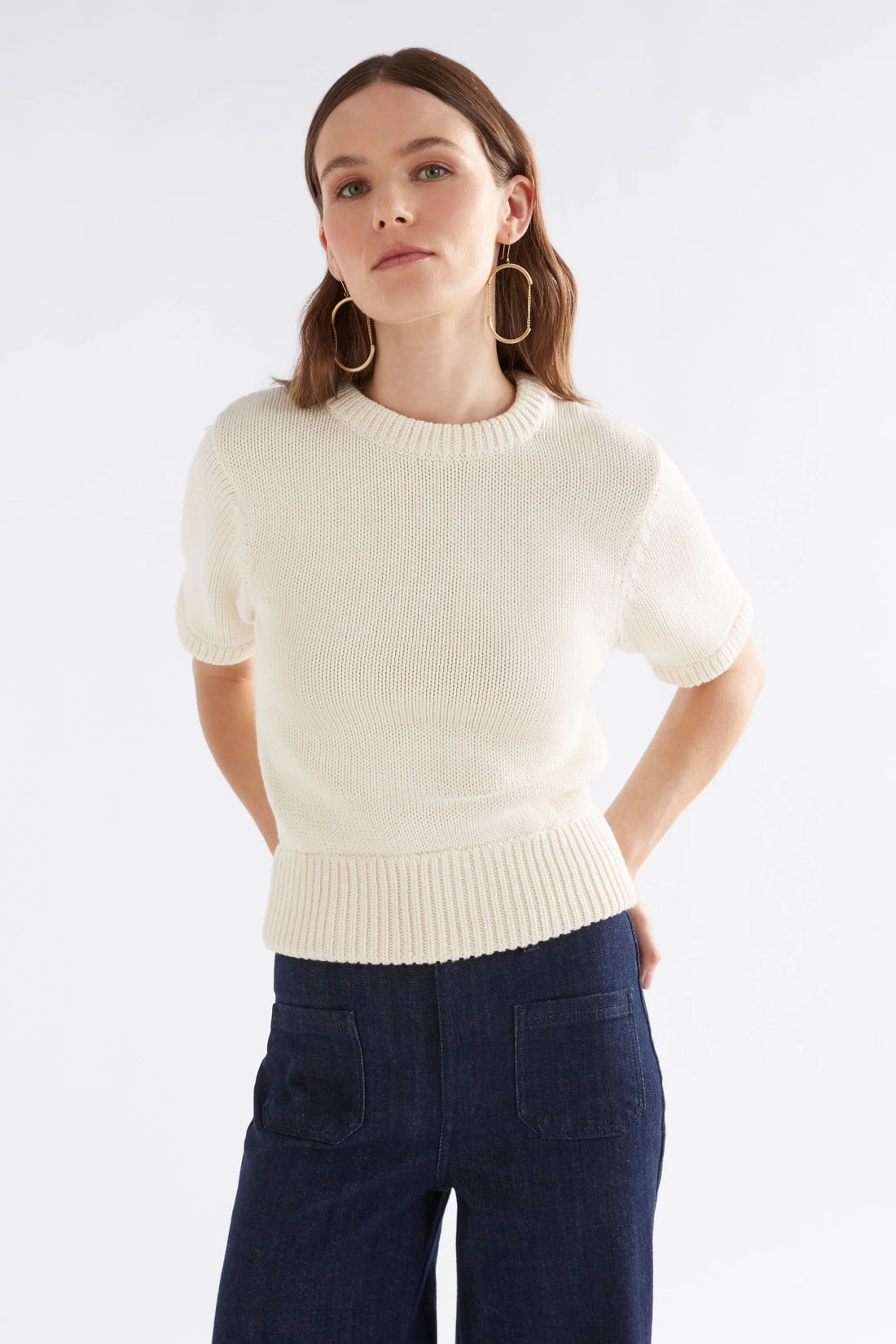 Woman wearing Luft Knit Top in white and denim pants