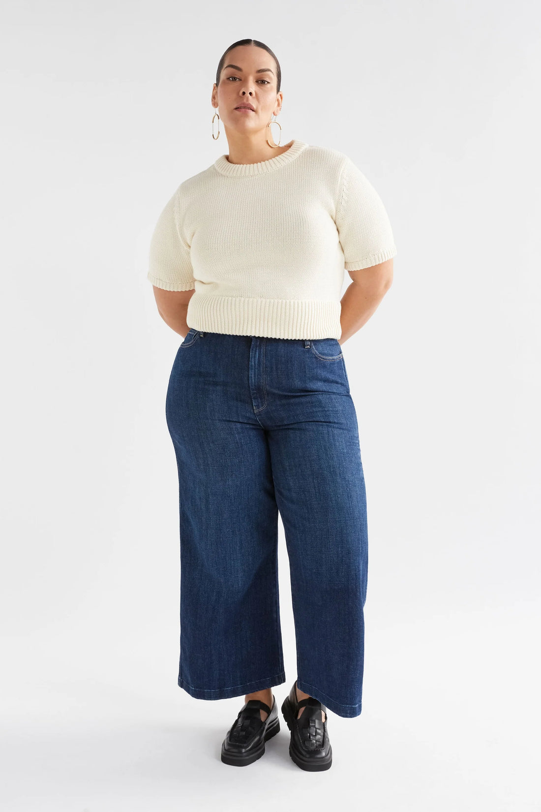 Plus size Woman wearing Luft Knit Top in white and denim pants