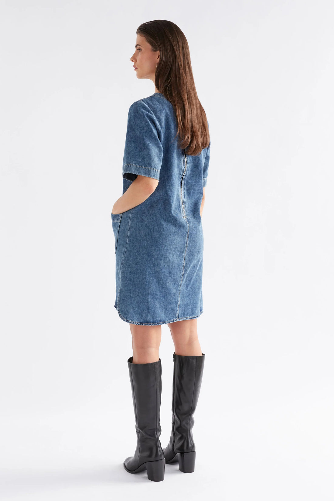 Woman facing the back wearing Rittra Denim Dress in Chambray Blue and black boots 