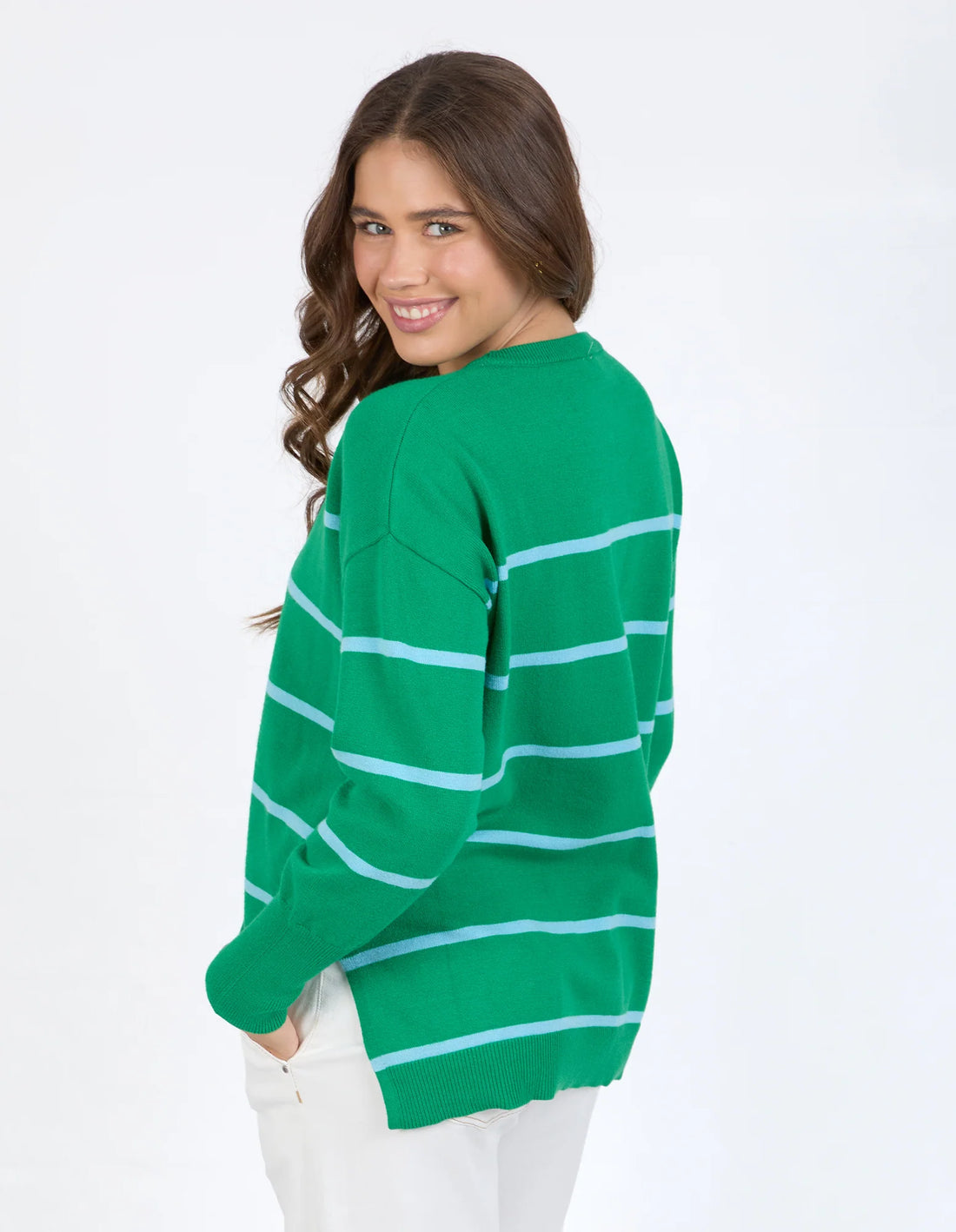 Woman wearing Charli Stripe Knit - Pine Green and white pants back view