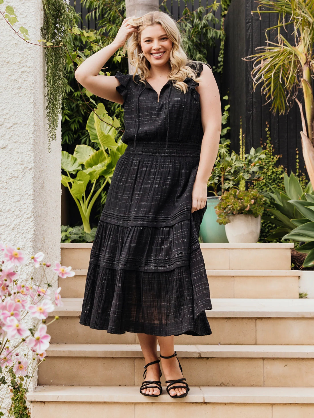 Woman wearing elm lifestyle Isabella dress in black and black sandals