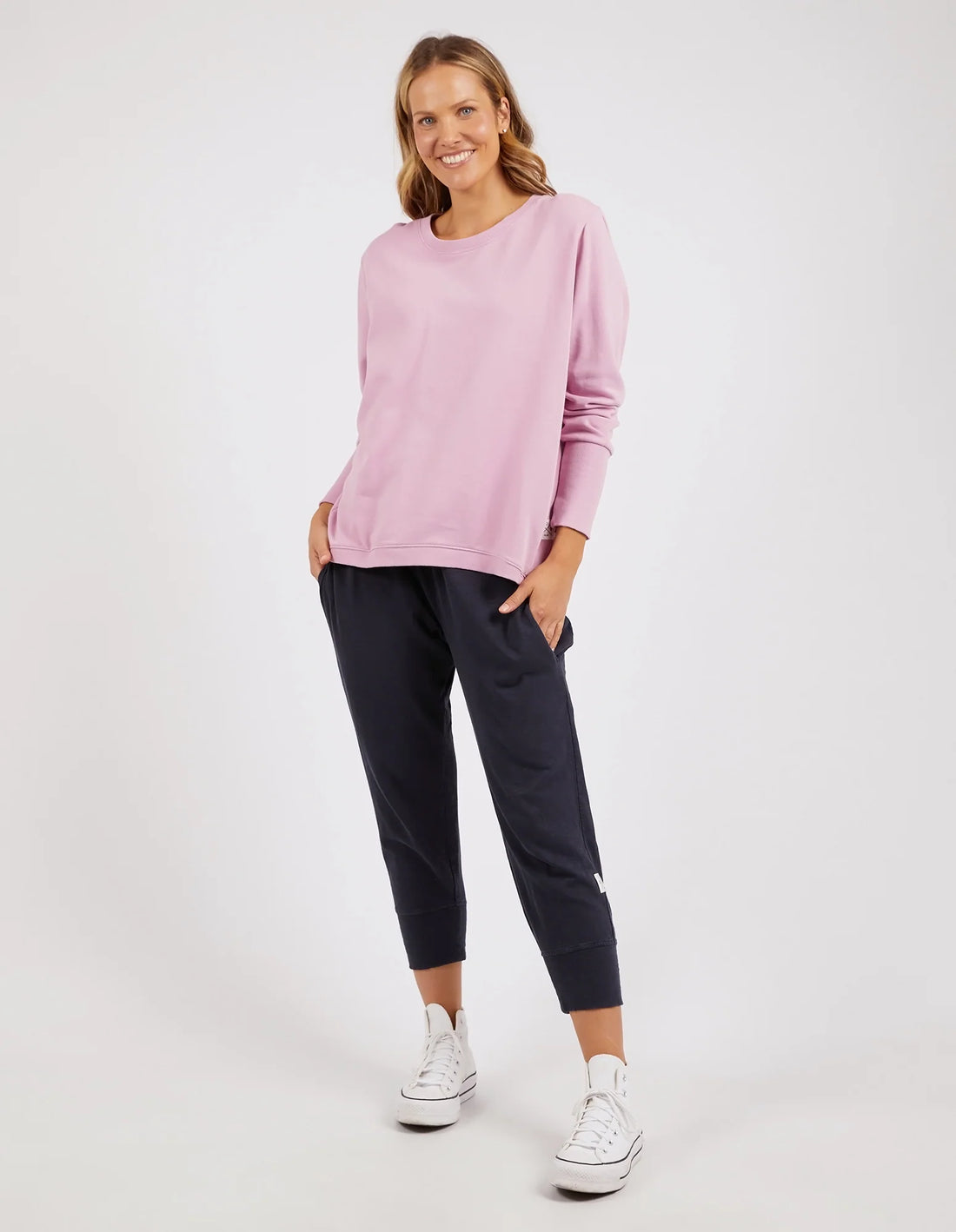 Woman wearing Divine Crew Peony Pink and black pants