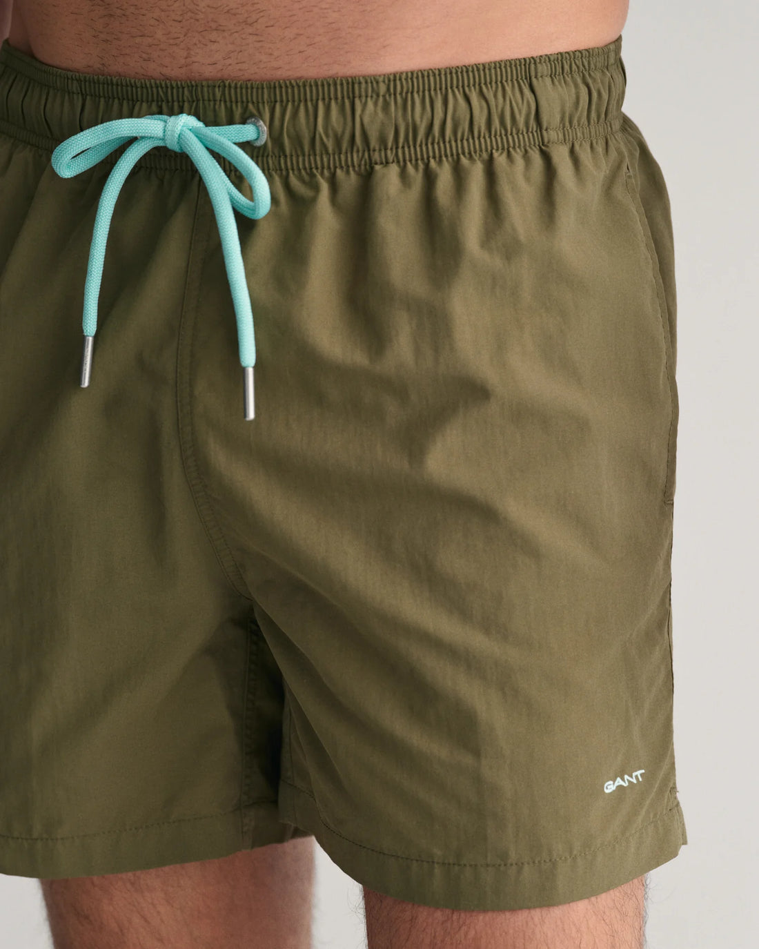 man wearing gant basic swim shorts juniper green