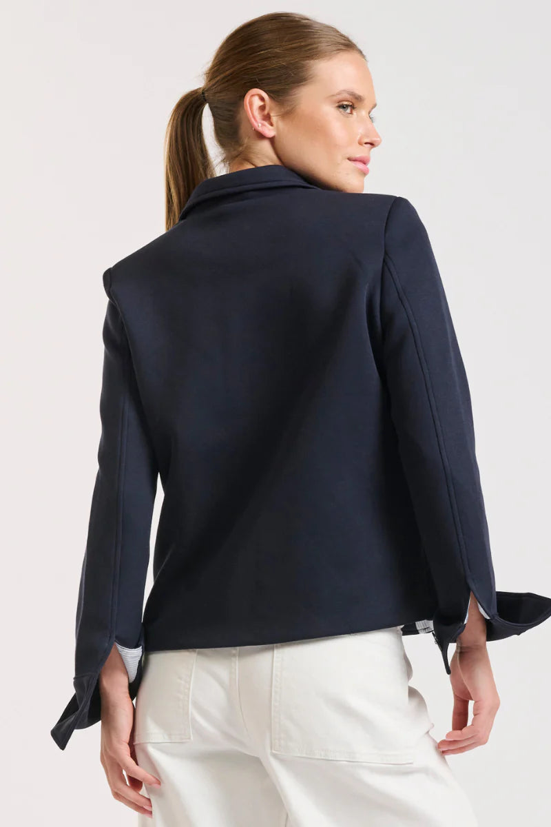 Woman facing the back wearing Hemming Scuba Jacket - French Navy and white pants