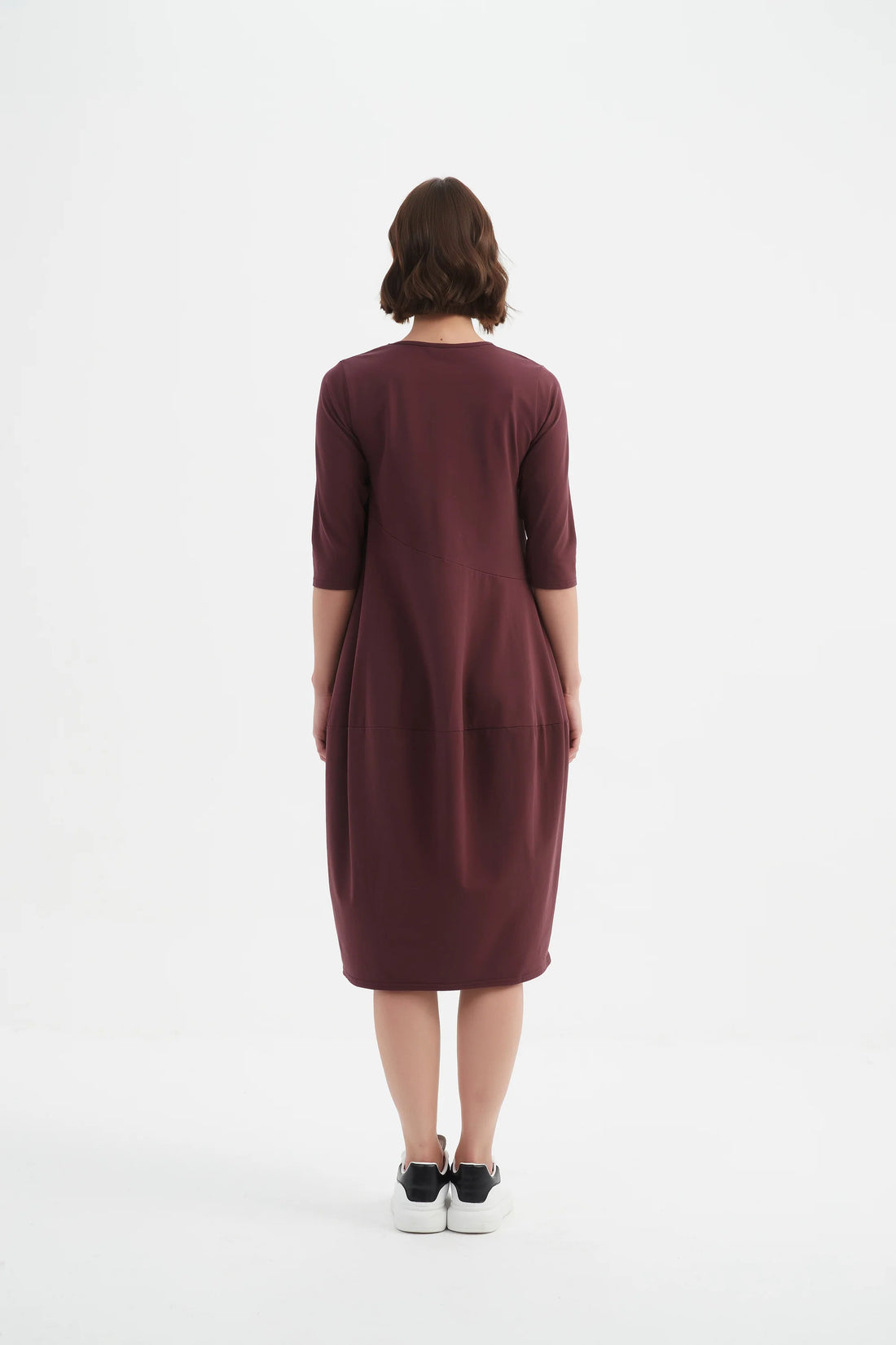 Woman wearing Woman wearing Diagonal Seam Winter Dress - Aubergine and white shoes facing the back