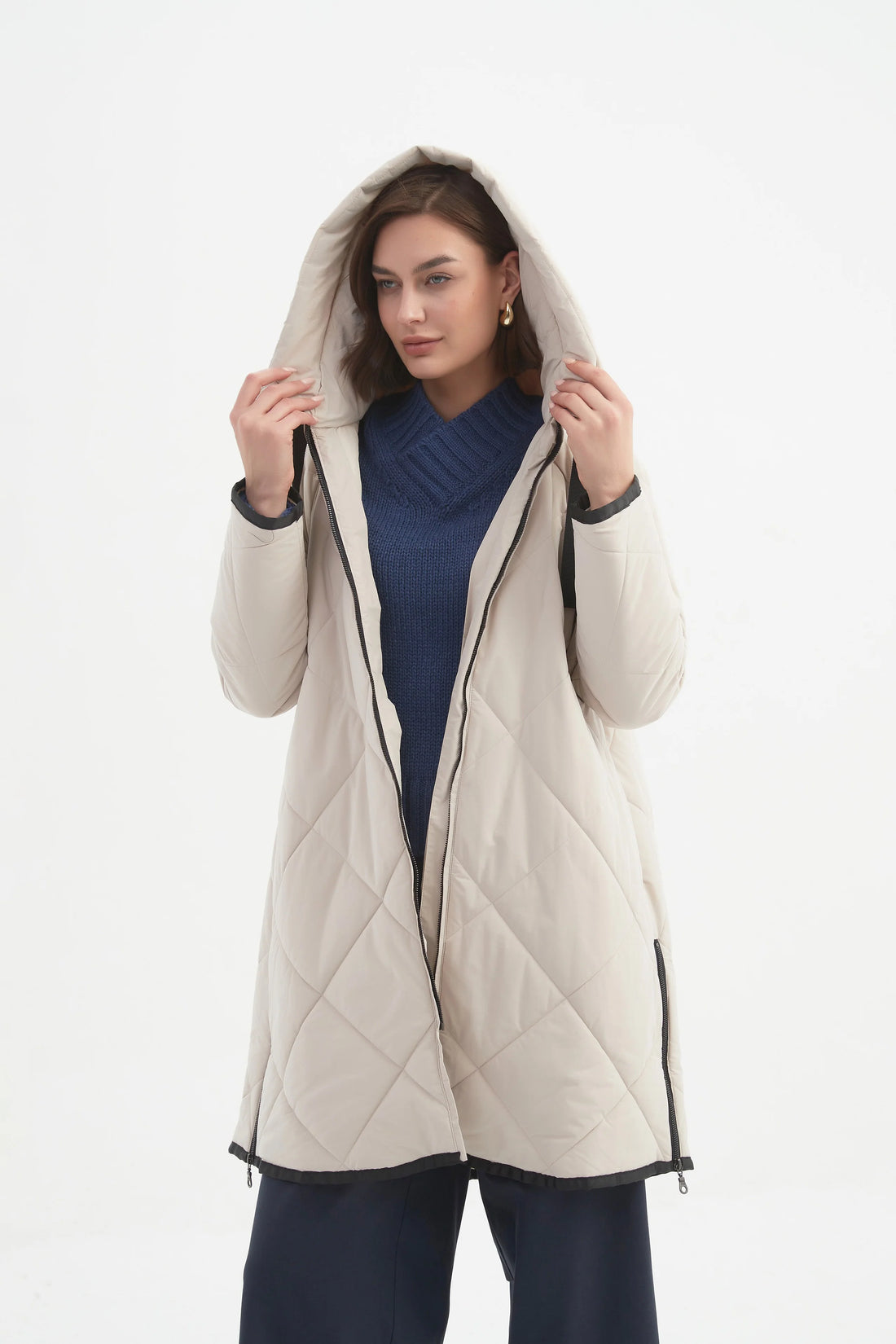 Woman wearing navy blue top and navy pants with Zip Hem Winter Coat - Cream