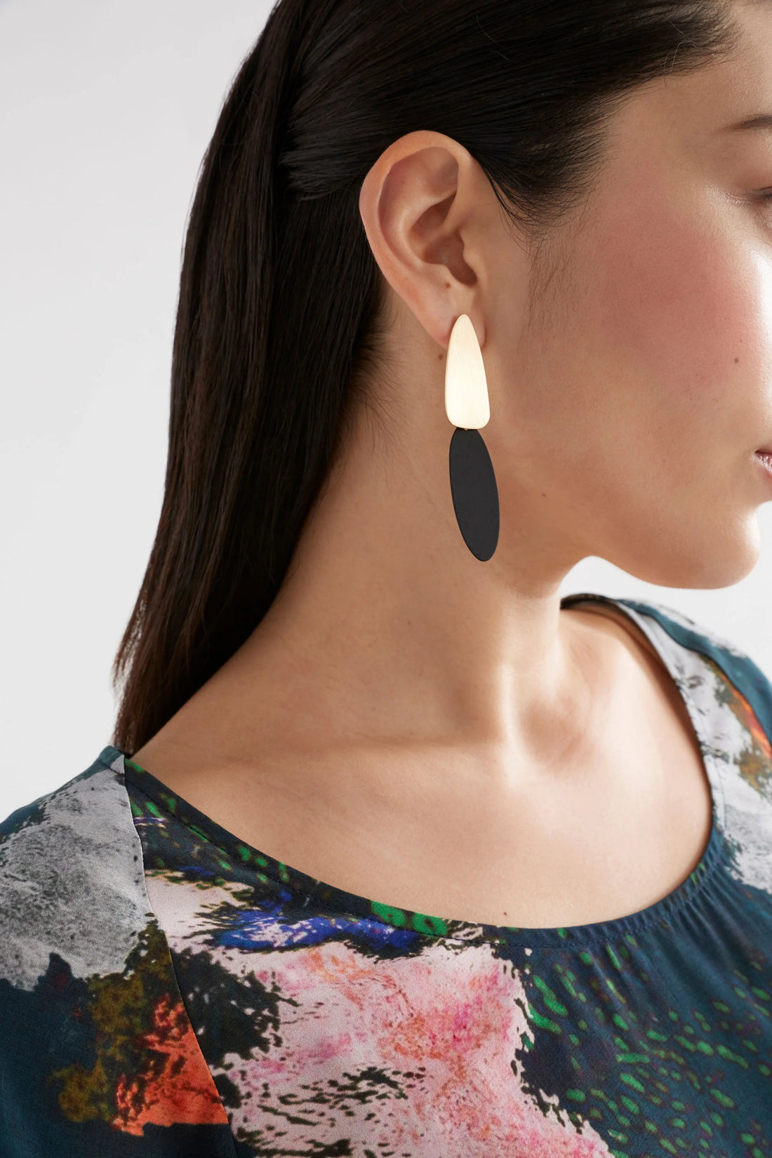 woman wearing floral print shirt and elk finn long drop earring black