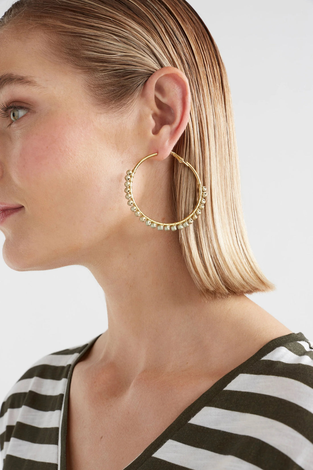 woman wearing a stripe shirt and elk oko hoop earring ecru