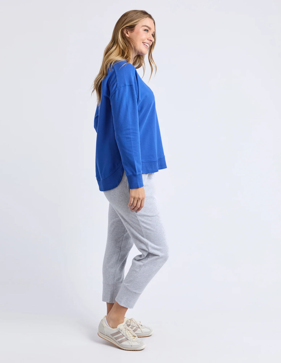 Woman facing the side wearing Established Crew - French Blue and grey jogger pants