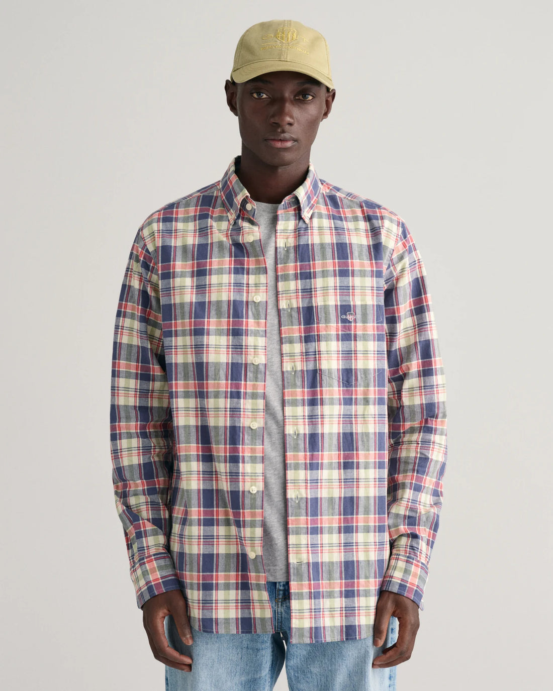 man wearing cap, denim pants, gant regular fit checkered cotton linen shirt in dusty blue sea with inner grey shirt