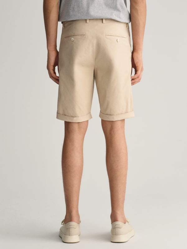 man wearing gant sunfaded shorts in dry sand and shoes