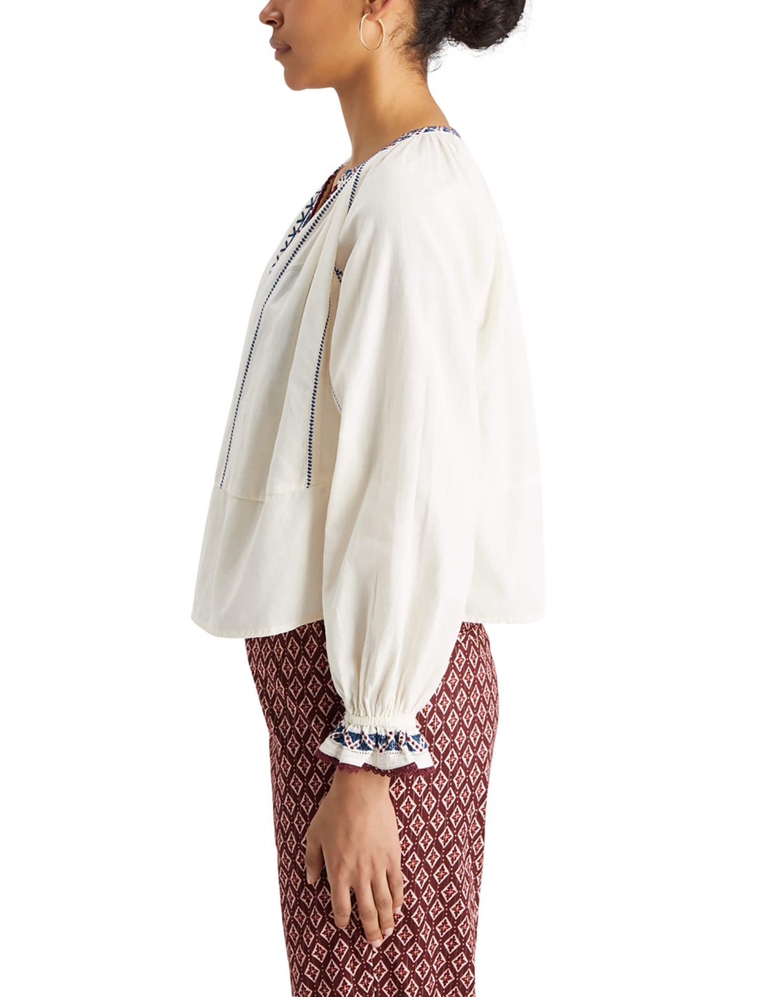 woman facing the side wearing Embroidered Blouse - Soft Ice and geo pattern pants