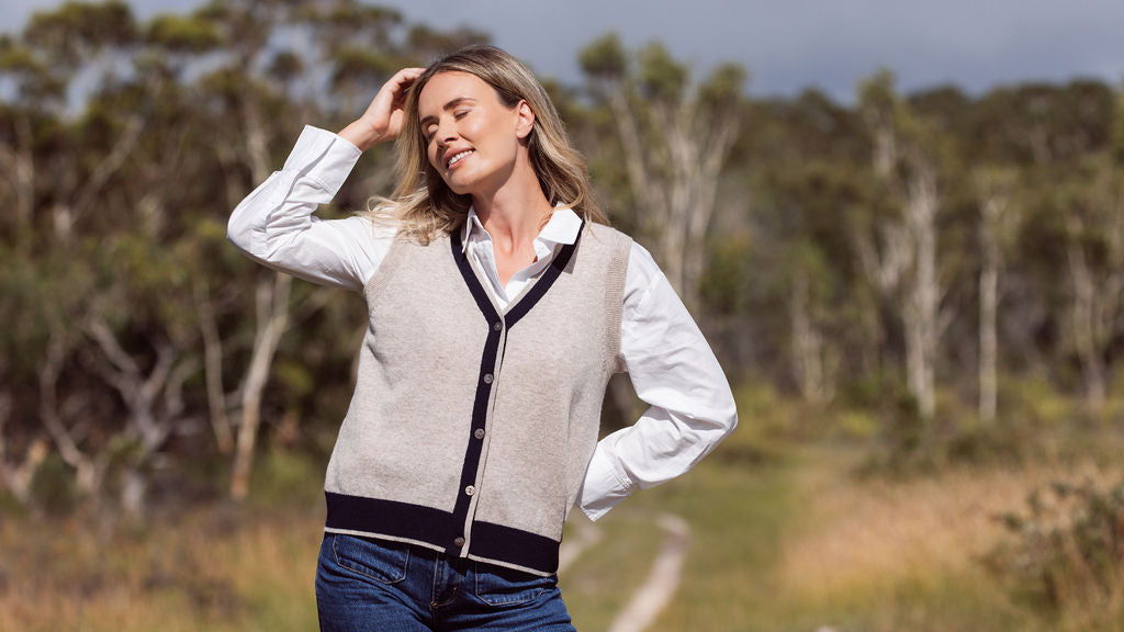 woman wearing white top, denim pants, and woman wearing 100% Luxe Merino Buttun Front Vest - Natural/Navy
