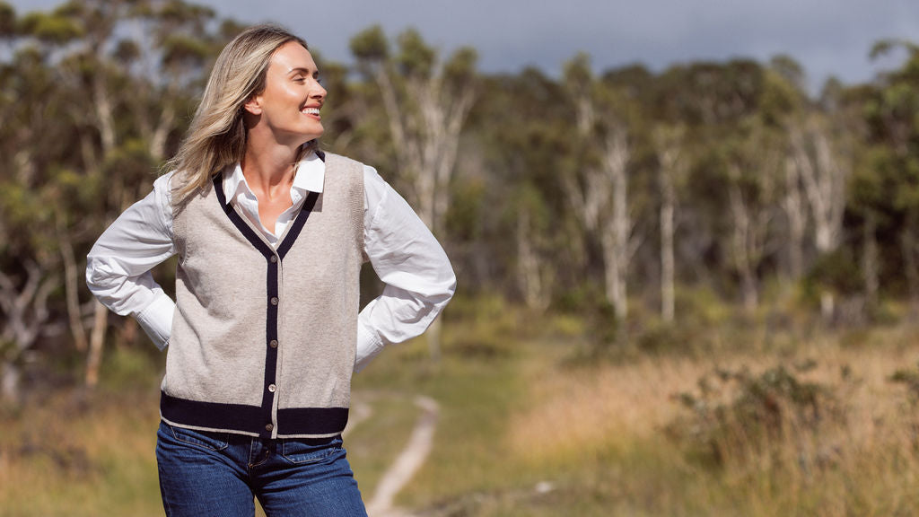 woman wearing whitw top, dark denim pants, and 100% Luxe Merino Buttun Front Vest - Natural/Navy
