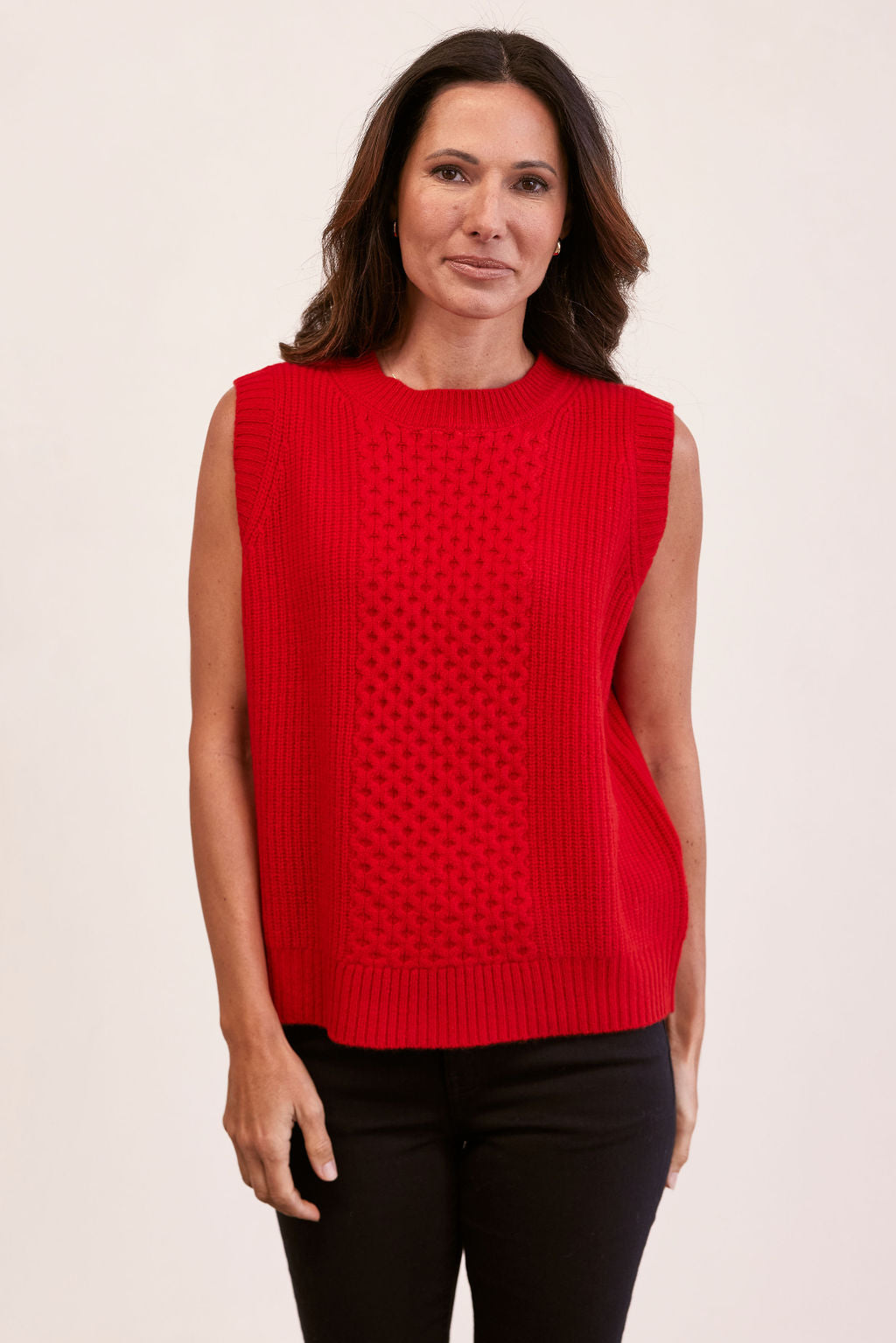 woman wearing 100% Luxe Merino Wool Cable Vest- Red and black pants