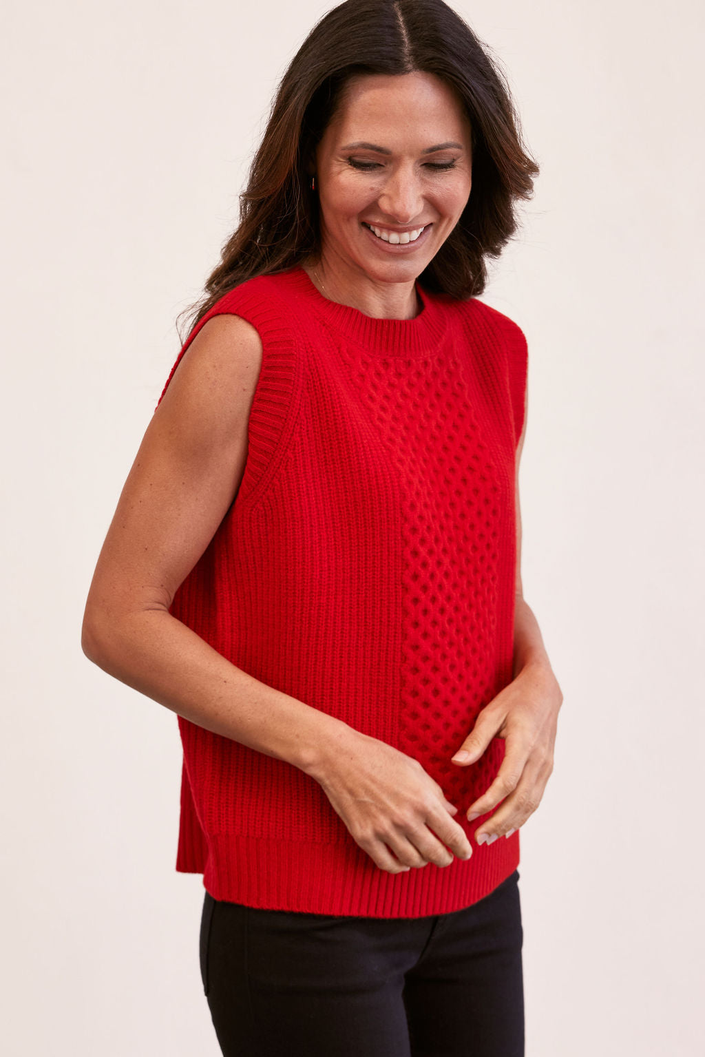woman wearing 100% Luxe Merino Wool Cable Vest- Red and black pants