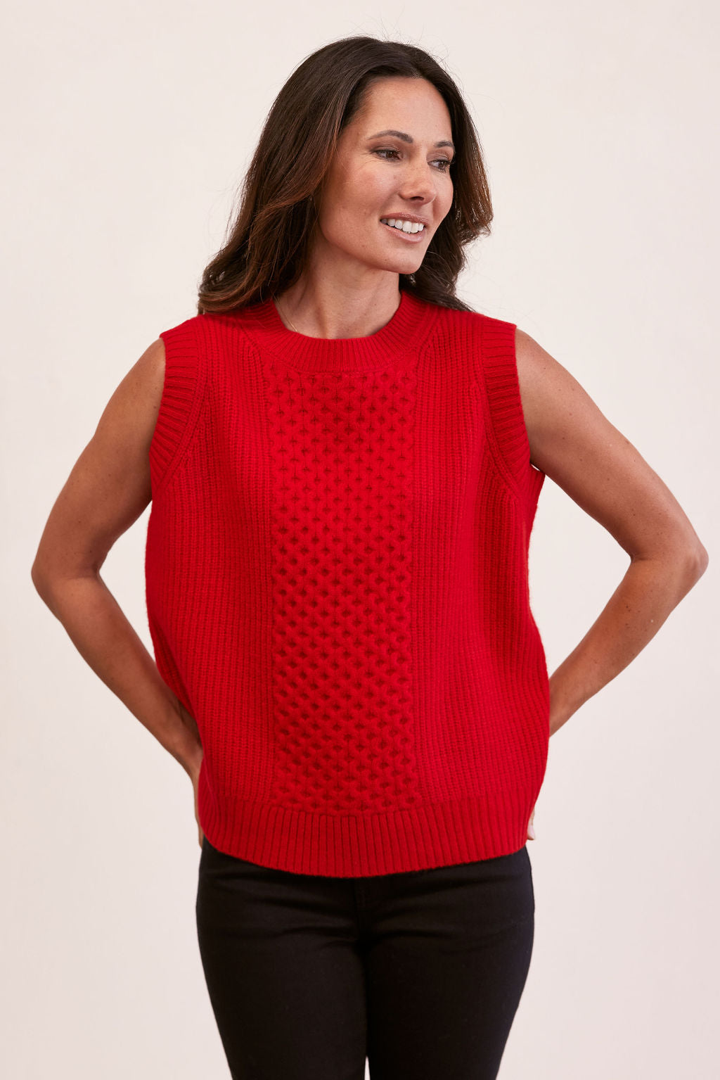 woman wearing 100% Luxe Merino Wool Cable Vest- Red and black pants
