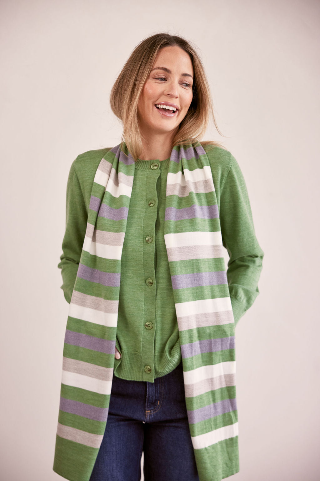 woman wearing Merino Wool Stripe Scarf Sage Combo and dark denim pants