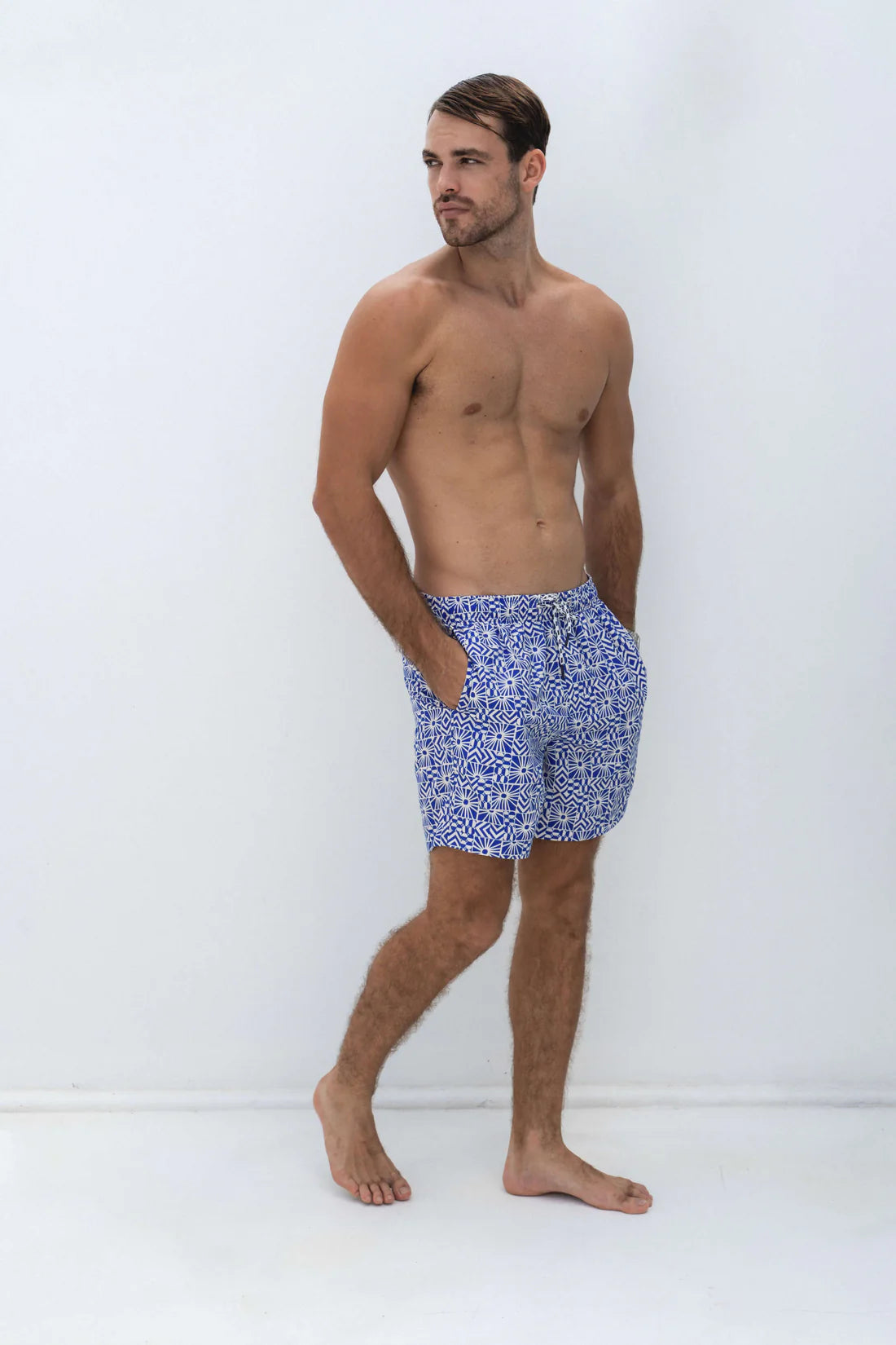 Man wearing shore club swim mens swim short in mediterranean sun design